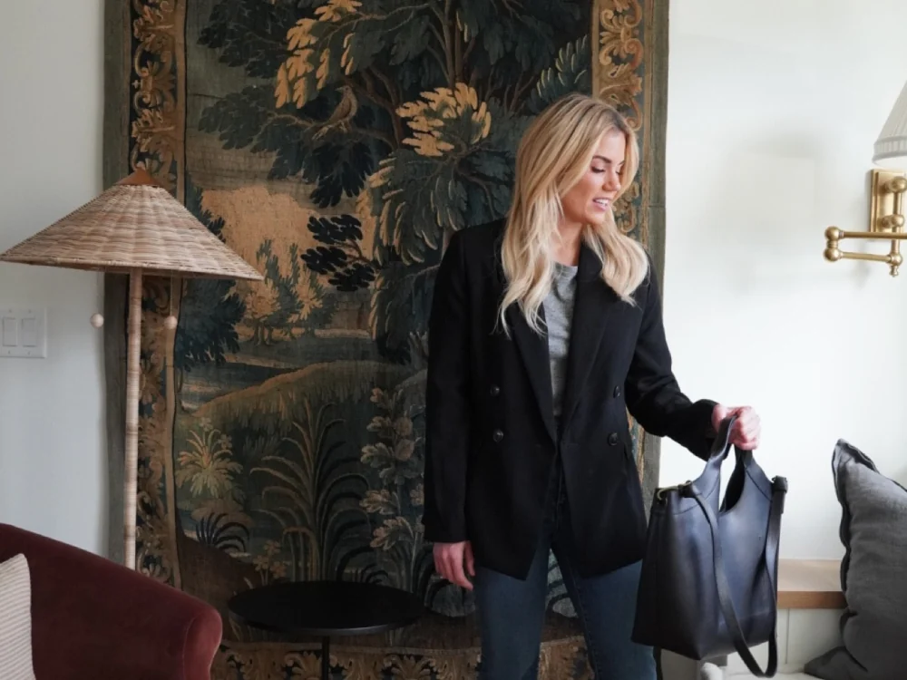 A creator in a black blazer holding a leather tote, from the LTK × Madewell sale.